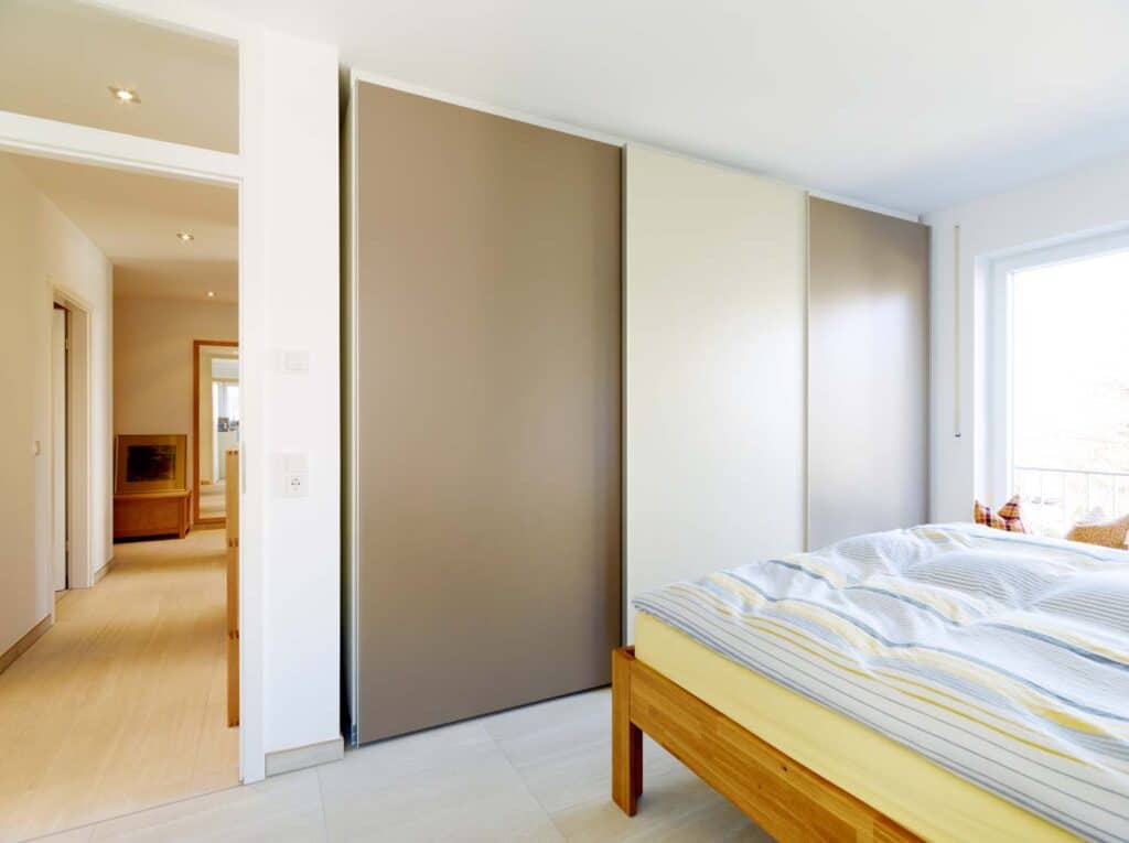Einbauschrank Massivholz mit dunkelbraunen Türen, in einem Schlafzimmer, mit Blick auf Flur